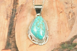Genuine High Grade Kingman Web Turquoise set in Sterling Silver Pendant. Created by Navajo Artist Phillip Sanchez. Signed by the artist. The Mineral Park Mine, in the Cerbat Mountains 14 miles northwest of Kingman, was first mined by Indians centuries before white man came to the area. It is one of the three sites of prehistoric mining localities in the state of Arizona. Mineral Park was the most extensively worked area by the Indians of the three. S.A. �Chuck� Colbaugh found a cache of stone hammers uncovered in ancient trenches and tunnels, when he had the turquoise mining concession in May of 1962. Ithaca Peak and Turquoise Mine (formally called Aztec Mountain or Aztec Peak) are the most famous of the peaks in the area containing turquoise. Free 18